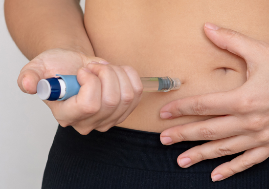 Young woman administering GLP-1 injection to her abdomen
