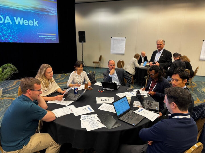 Various attendees at a round table working together in an activity