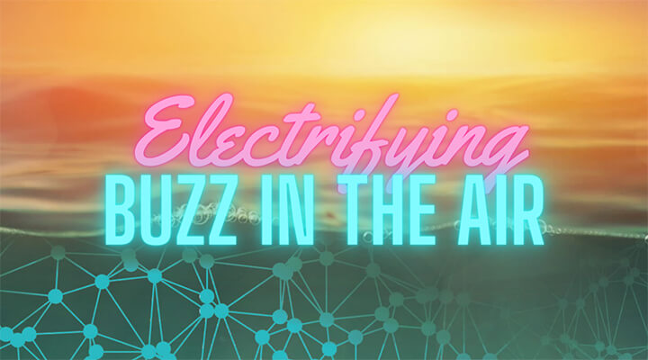 Neon text writing 'Electrifying Buzz In The Air' against a sunset over a calm ocean