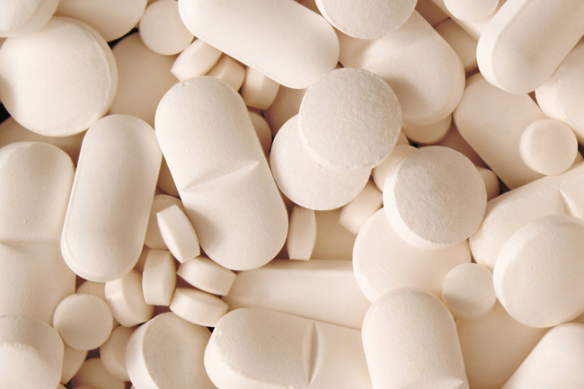 An assortment of white pills in different shapes and sizes