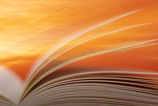 A book open against a background of a sunrise