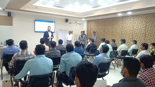 Attendees seated in a presentation being addressed by members of the team